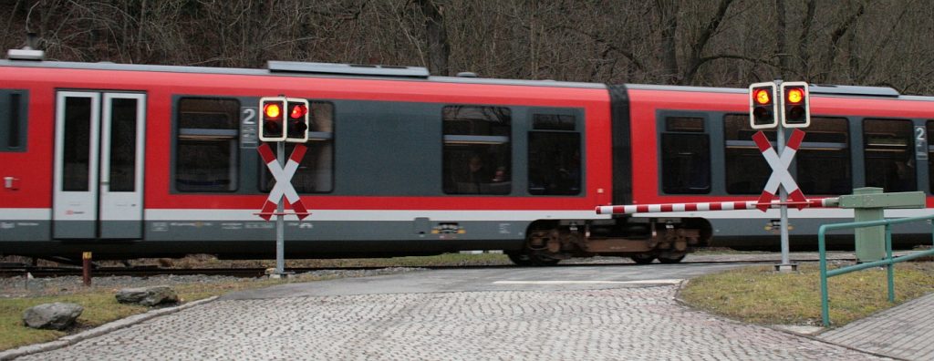 Triebwagen fährt über einen Bahnübergang
